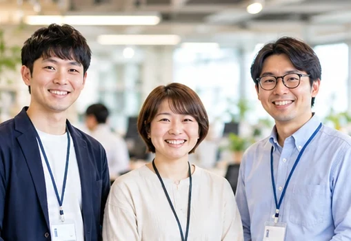 オフィスで並んで笑顔を見せる3人のメンバー