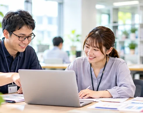 ノートPCを見ながら打ち合わせをする2人
