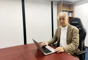 ノートPCを前に執務室の机に座る組合代表 吉見 祐次